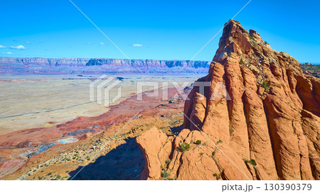 Aerial Red Sandstone Formation and Desert Plateau with Distant Mesas Fly Over 130390379