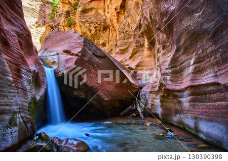 Waterfall Motion Over Angular Boulder in Striated Sandstone Canyon Eye Level View Waterfall Motion Over Angular Boulder in Striated Sandstone Canyon Eye Level View 130390398