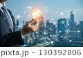 A businessman holds a glowing light bulb symbolizing innovation and new ideas, connected to a digital network representing technology and business solutions A businessman holds a glowing light bulb symbolizing innovation and new ideas, connected to a digital network representing technology and business solutions 130392806