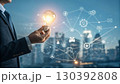 A businessman holds a glowing light bulb symbolizing innovation and new ideas, connected to a digital network representing technology and business solutions A businessman holds a glowing light bulb symbolizing innovation and new ideas, connected to a digital network representing technology and business solutions 130392808