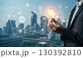 A businessman holds a glowing light bulb symbolizing innovation and new ideas, connected to a digital network representing technology and business solutions A businessman holds a glowing light bulb symbolizing innovation and new ideas, connected to a digital network representing technology and business solutions 130392810