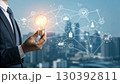 A businessman holds a glowing light bulb symbolizing innovation and new ideas, connected to a digital network representing technology and business solutions A businessman holds a glowing light bulb symbolizing innovation and new ideas, connected to a digital network representing technology and business solutions 130392811