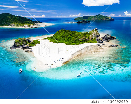 嘉比島のドローン撮影。白砂のビーチには観光客が上陸している。 パラソルやボート、サバニが停まっている 嘉比島のドローン撮影。白砂のビーチには観光客が上陸している。 パラソルやボート、サバニが停まっている 130392979