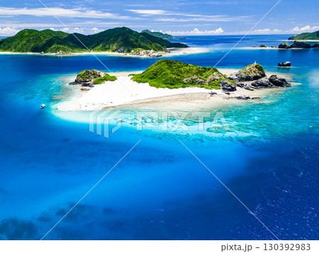 嘉比島のドローン撮影。白砂のビーチには観光客が上陸している。 パラソルやボート、サバニが停まっている 130392983