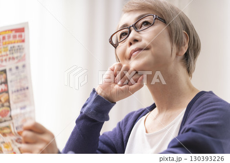 スーパーのチラシを見るシニア女性 スーパーのチラシを見るシニア女性 130393226