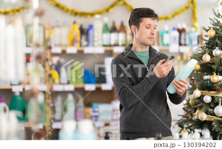 Adult man scanning qr code for shampoo or shower gel 130394202