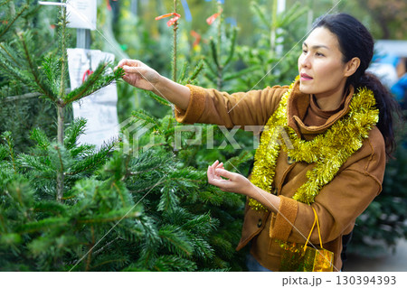 Portrait of asian woman buying Christmas tree at Christmas market 130394393