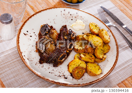 Churrasco grilled veal ribs with baked potatoes and garlic aioli 130394416