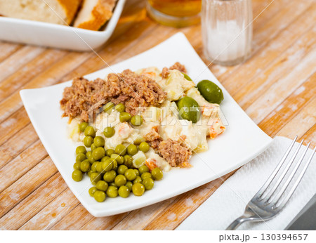 Russin salad with minced canned tuna, olives and pickled peas 130394657