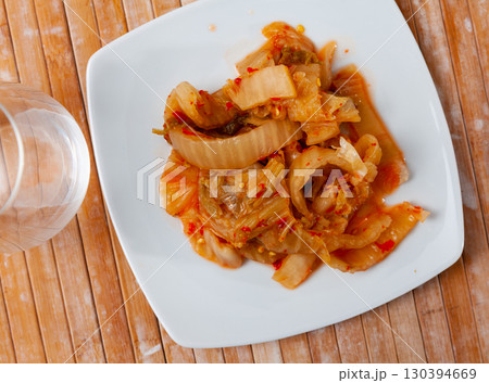 Kimchi cabbage in bowl with chopsticks for eating on wooden background, top view, Korean food 130394669