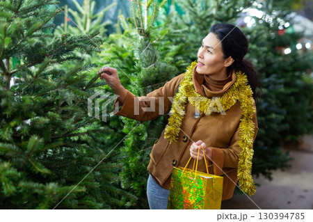 Portrait of asian woman buying Christmas tree at Christmas market Portrait of asian woman buying Christmas tree at Christmas market 130394785