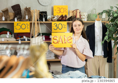 Teen holding poster with the inscription sale Teen holding poster with the inscription sale 130394865