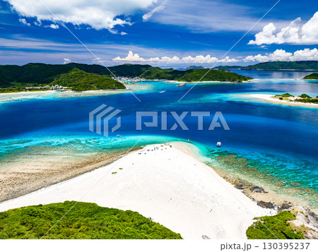嘉比島のドローン撮影。白砂のビーチに観光客が上陸。 パラソルが立ち、ボート、サバニが停泊している。 嘉比島のドローン撮影。白砂のビーチに観光客が上陸。 パラソルが立ち、ボート、サバニが停泊している。 130395237