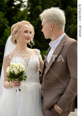 Couple exchanging vows in a garden during a romantic wedding ceremony Couple exchanging vows in a garden during a romantic wedding ceremony 130395276