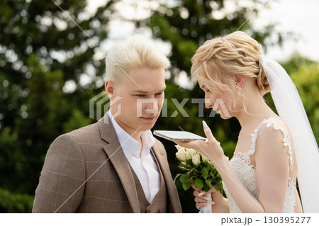 Bride and groom sharing a moment during wedding ceremony in a garden Bride and groom sharing a moment during wedding ceremony in a garden 130395277