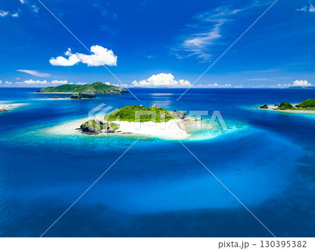 嘉比島のドローン撮影。白砂のビーチに観光客が上陸。 パラソルが立ち、ボート、サバニが停泊している 嘉比島のドローン撮影。白砂のビーチに観光客が上陸。 パラソルが立ち、ボート、サバニが停泊している 130395382