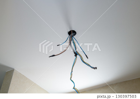 Detail of exposed electrical wiring during house renovation. chaotic construction process on ceiling shows complexity and anticipation of home improvement work 130397503