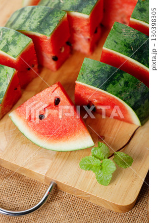 Slices of fresh watermelon on rustic wooden background. 130398305