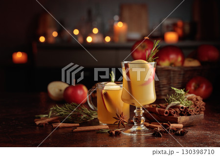 Mulled cider with apples, cinnamon, rosemary, and anise on a background of burning candles. 130398710