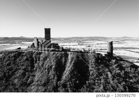 Hazmburk castle ruins rise sharply in the Central Bohemian Uplands, surrounded by expansive fields and rolling hills. This medieval structure offers breathtaking views of the serene landscape. Hazmburk castle ruins rise sharply in the Central Bohemian Uplands, surrounded by expansive fields and rolling hills. This medieval structure offers breathtaking views of the serene landscape. 130399270