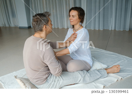 Couples engaging in mindfulness practice during a wellness retreat in a serene studio setting focused on emotional connection and relaxation techniques Couples engaging in mindfulness practice during a wellness retreat in a serene studio setting focused on emotional connection and relaxation techniques 130399461