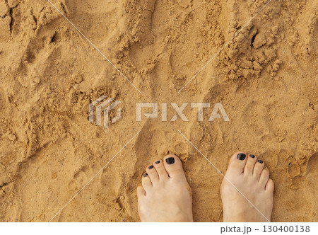 Warm golden sand stretches out under bare feet, feeling soft and inviting. The sunlight creates a bright atmosphere perfect for enjoying the beach on a sunny afternoon Warm golden sand stretches out under bare feet, feeling soft and inviting. The sunlight creates a bright atmosphere perfect for enjoying the beach on a sunny afternoon 130400138