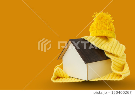 Miniature house wrapped in warm clothing ready for cold weather 130400267