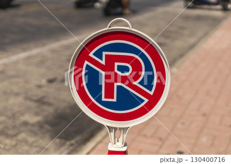 A no parking sign stands prominently on a street corner, clearly visible to passing traffic A no parking sign stands prominently on a street corner, clearly visible to passing traffic 130400716