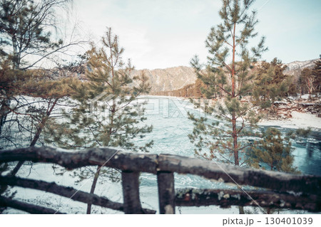 winter mountain river with turquoise water flowing through snowy forest framed by pine trees and wooden fence, concept of nature travel, scenic landscape, ecology and outdoor tourism winter mountain river with turquoise water flowing through snowy forest framed by pine trees and wooden fence, concept of nature travel, scenic landscape, ecology and outdoor tourism 130401039