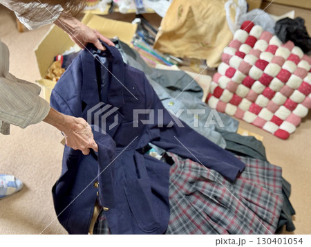 女子学生のブレザーを持つ高齢女性の手元 130401054