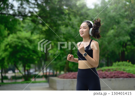 Fit female athlete running in the park, enjoying exercise and a healthy lifestyle 130401415