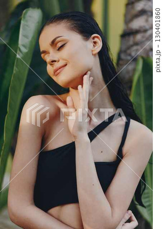 Tropical Paradise Stunning Young Woman in Black Bikini Posing in Front of Palm Tree Under the Sunlit Sky Tropical Paradise Stunning Young Woman in Black Bikini Posing in Front of Palm Tree Under the Sunlit Sky 130401860