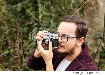 portrait of a man, a professional photographer, in a forest, with a focus on a simple and an elegant design. outdoor photography adventure. wildlife photographer lifestyle portrait of a man, a professional photographer, in a forest, with a focus on a simple and an elegant design. outdoor photography adventure. wildlife photographer lifestyle 130402490