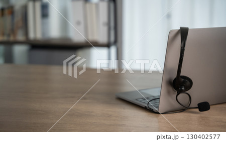 Laptop with headset on wooden desk, symbolizing Laptop with headset on wooden desk, symbolizing 130402577
