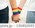 Asian LGBT couple woman holding hand wearing rainbow wristband. 130402693