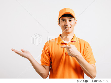 Portrait Asian smiling young delivery man points something with palm hands studio isolated white background, Happy lifestyle men carry person in an orange shirt uniform happy and positive mood Portrait Asian smiling young delivery man points something with palm hands studio isolated white background, Happy lifestyle men carry person in an orange shirt uniform happy and positive mood 130402809