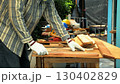 Carpenter aligning wooden planks on workbench while wearing gloves and protective gear for woodworking 130402829