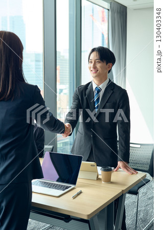 握手をするビジネスパーソン 130403348
