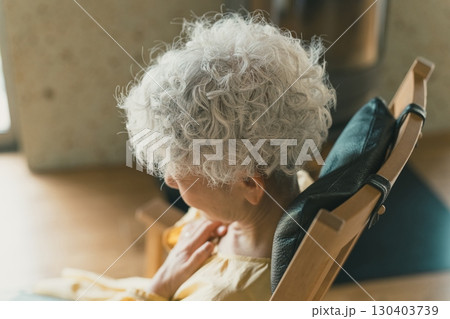 自宅で胸の痛みを感じる高齢者女性 130403739