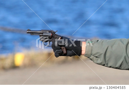 警察による銃器犯罪対処訓練の情景：回転式けん銃を向ける容疑者の腕 130404585