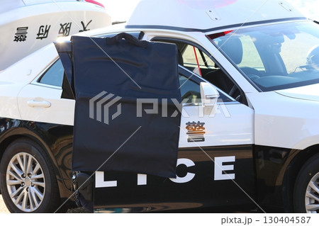 警察による銃器犯罪対処訓練の情景：防弾バッグをドア枠にかけ応戦する警察官の演出 130404587