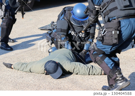警察による銃器犯罪対処訓練の情景：犯人を地面にねじ伏せる機動隊員の演出 130404588