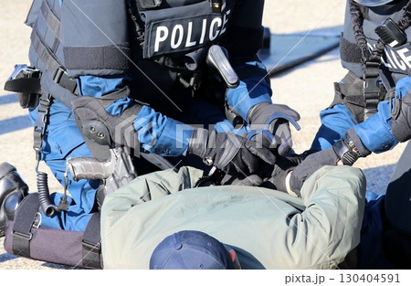 警察による銃器犯罪対処訓練の情景：確保した犯人に手錠を掛ける機動隊員の演出 130404591