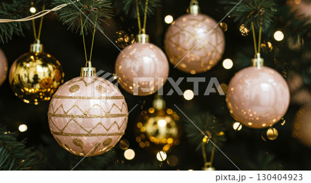 Christmas tree decorated with shiny pink and gold ornaments and glowing lights, creating a beautiful festive atmosphere. Christmas tree decorated with shiny pink and gold ornaments and glowing lights, creating a beautiful festive atmosphere. 130404923