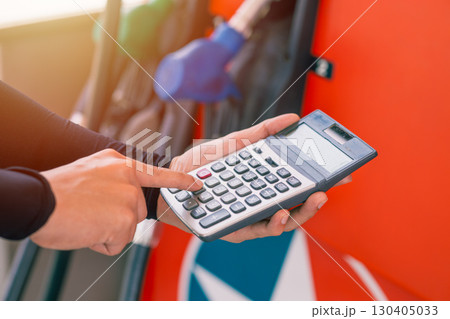 Closeup gas station staff worker hand calculator calculate price car fuel cost, Petroleum business 130405033