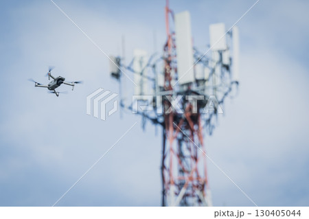 Drone UAV flying on the sky against communication tower for use cell site network to control operate 130405044