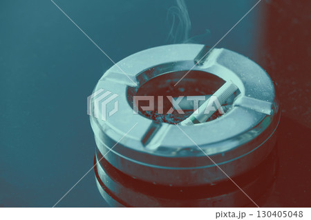 Closeup finished Cigarette butts in ashtray on black empty copy space table top with color effect 130405048
