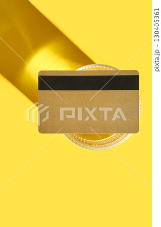 Golden credit card on vibrant yellow background with dramatic shadow and glass Golden credit card on vibrant yellow background with dramatic shadow and glass 130405361