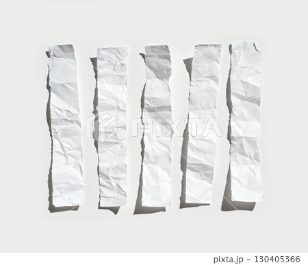 Crumpled strips of white paper neatly aligned on a light gray background 130405366