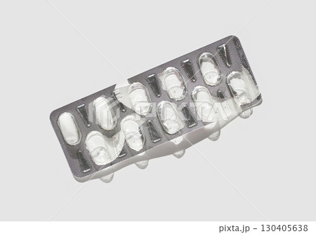 Empty blister pack with silver foil on white background highlighting medication Empty blister pack with silver foil on white background highlighting medication 130405638